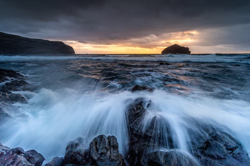 Crashing waves on rocky shore at sunset, São Miguel, Azores